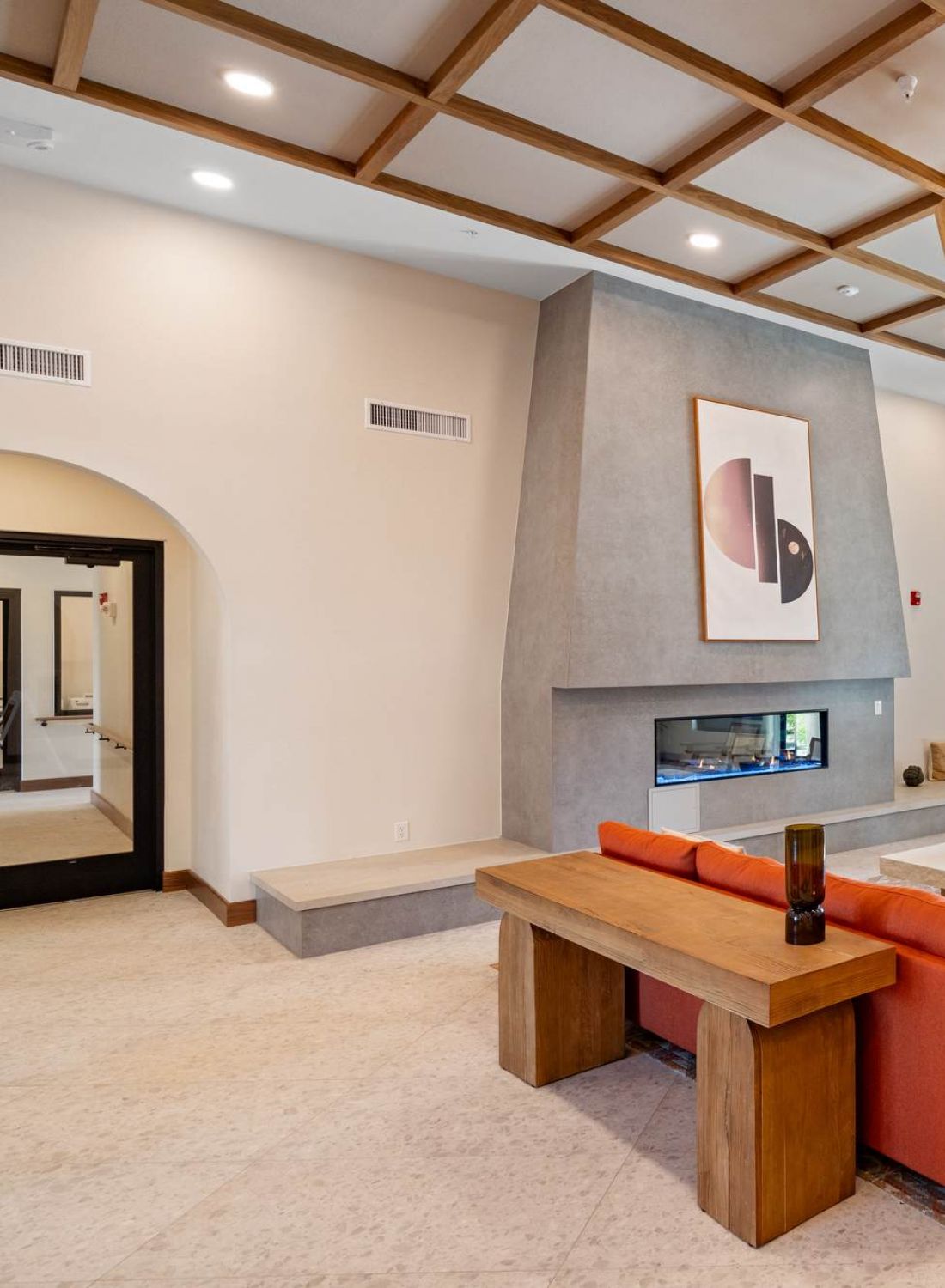 Modern lounge with a red sectional sofa, fireplace, large windows, and contemporary decor.